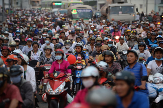 Với nhiều người nghèo, việc thu phí xe máy là một gánh nặng. Trong ảnh: người dân chen chúc đi xe qua cầu Chà Và, Q.8, TP.HCM - Ảnh: Thuận Thắng