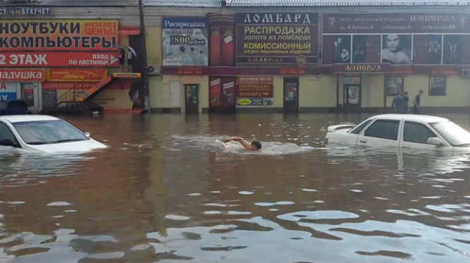 Một người đàn ông bơi trong dòng nước ngập đường phố Kursk, Nga - Ảnh: RT