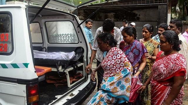 Thân nhân những người chết vì ngộ độc rượu giả đang nhận thi hài người nhà tại bệnh viện đa khoa Bhagwati tại Mumbai, Ấn Độ ngày 19-6 - Ảnh: EPA