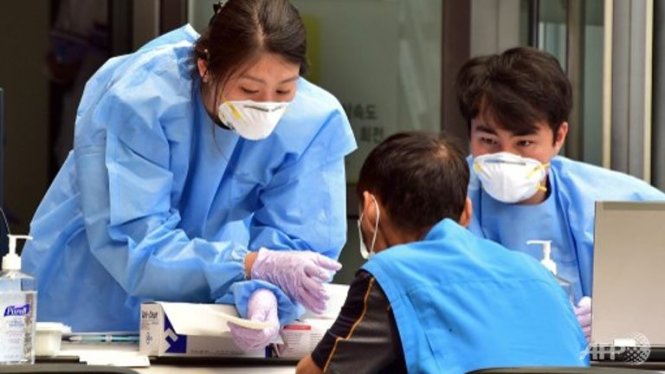 Nhân viên y tế Hàn Quốc kiểm tra thân nhiệt một người thăm bệnh Ảnh: AFP