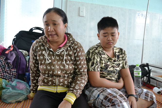 Hai mẹ con chị Đỗ Thị Huệ ( vợ nạn nhân Vũ Văn Nam) đang ở Trung tâm y tế Phước Sơn) - Ảnh: Lê Trung