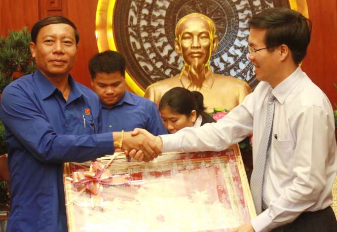 Phó bí thư thường trực Thành ủy TP.HCM Võ Văn Thưởng (bìa phải) nhận quà lưu niệm của Tỉnh đoàn Champasak (Lào) tặng tại buổi tiếp - Ảnh: Q.L.