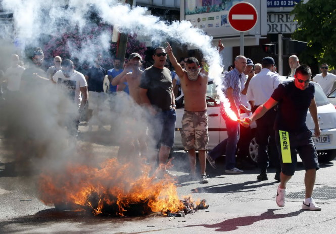 Tài xế taxi đốt vỏ xe trên đường phố trong cuộc biểu tình chống Uber ở Marseille - Ảnh: Reuters