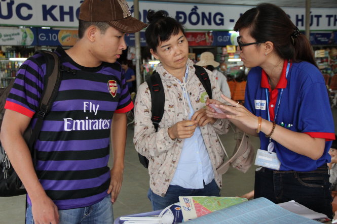 Sinh viên tình nguyện đang tư vấn, hỗ trợ thí sinh, phụ huynh sáng 26-6 tại bến xe Miền Đông - Ảnh: Phan Dương