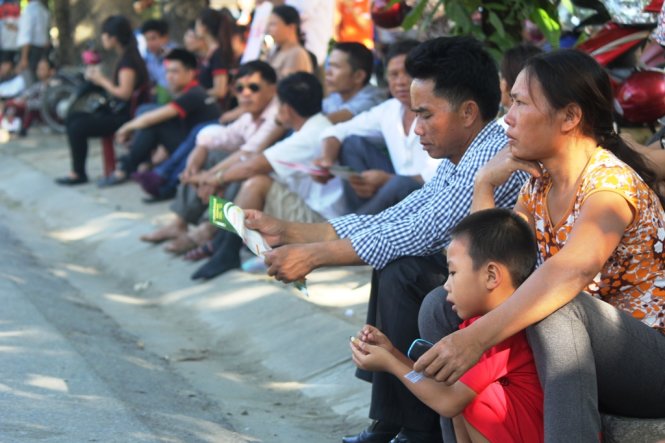 Phụ huynh ngồi “bó gối” dọc vỉa hè đường Lê Hồng Phong (TP Vinh, Nghệ An) - Ảnh: Doãn Hòa