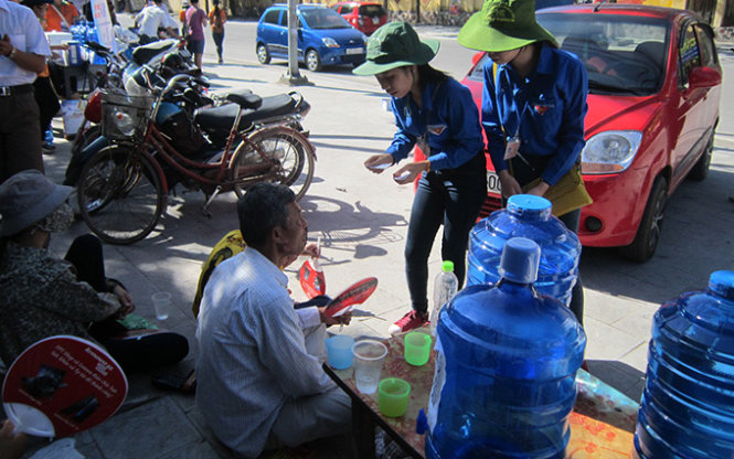 Các bạn TNTN Thanh Hóa phát phiếu nhận cơm miễn phí cho người nhà thí sinh trước cổng Trường THPT Đào Duy Từ sáng 1- 7- Ảnh: Hà Đồng
