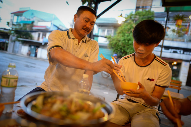 Anh Lý Thành Huy (huyện Bù Gia Mập, Bình Phước) đãi con một bữa ngon trước ngày thi ở một quán lẩu dê trên đường Lê Lợi, Q.Gò Vấp gần hội đồng thi ĐH Công nghiệp TP.HCM - Ảnh: Thuận Thắng