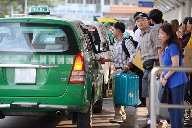 Hành khách đón taxi tại sân bay Tân Sơn Nhất (TP.HCM) - Ảnh: Thuận Thắng
