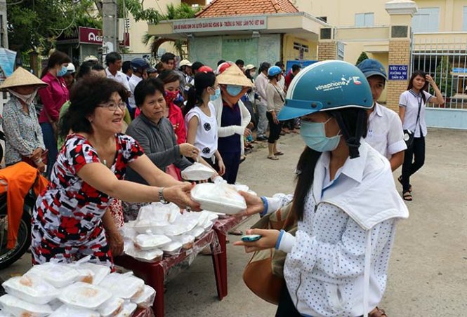 Tiểu thương chợ Trần Huỳnh (thành phố Bạc Liêu) phát cơm miễn phí cho thí sinh - Ảnh: Thảo Quyên