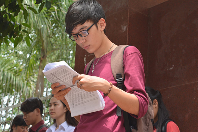 Thí sinh Phan Văn Ái, người đầu tiên bước ra khỏi phòng thi tại Trung tâm GDTX tỉnh Đắk Lắk, xem lại tài liệu sau khi kết thúc môn Sử - Ảnh: Lĩnh Hồng