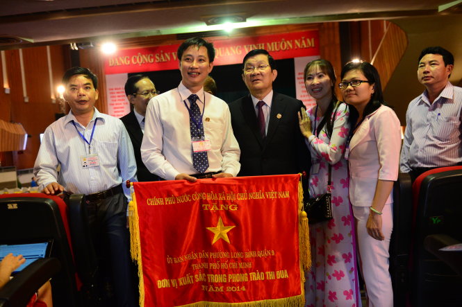 Chủ tịch nước Trương Tấn Sang và tập thể đại diện UBND P.Long Bình, Q.9, TP.HCM - đơn vị xuất sắc trong phong trào thi đua năm 2014 Ảnh: Q.ĐỊNH