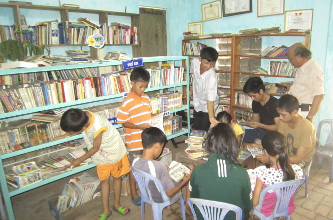 Trần Phước Ninh (giữa) và trẻ em đọc sách tại Thi hữu quán - Ảnh: Quang Cân