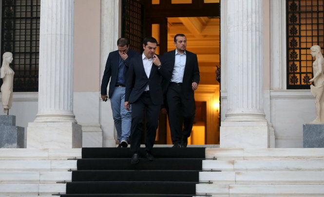 Thủ tướng Hi Lạp Alexis Tsipras (đi đầu) bước ra từ nhiệm sở của ông tại Athens - Ảnh: Reuters