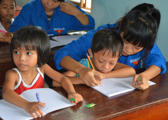 Thanh niên tình nguyện luyện chữ cho các em nhỏ tại thôn 7, xã Cư Róa, huyện M’Đrắk, Đắk Lắk - Ảnh: Võ Ngọc
