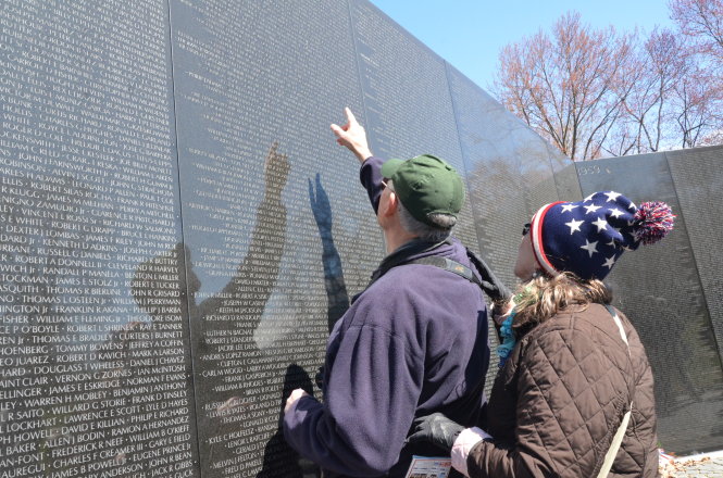 Một đôi vợ chồng Mỹ tìm thấy tên của người thân khắc trên bia đá tại Đài tưởng niệm lính Mỹ tử trận ở Việt Nam tại thủ đô Washington - Ảnh: QUỲNH TRUNG