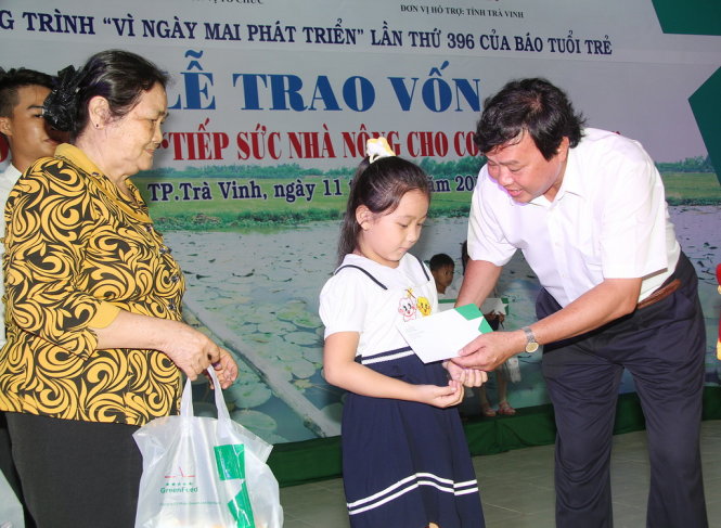 Ông Lê Văn Hẳn, phó chủ tịch UBND tỉnh Trà Vinh, trao vốn và quà cho nông dân và học sinh