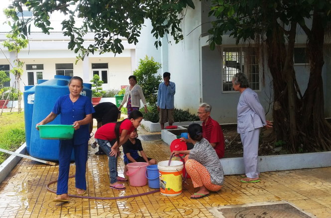 Người nhà bệnh nhân chờ hứng nước sạch sinh hoạt tại Bệnh viện Y học cổ truyền tỉnh Kiên Giang sáng 15-7 Ảnh: NHƯ NGỌC