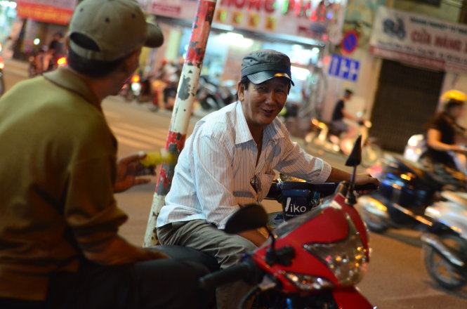 Ông Nguyễn Văn Thành, chạy xe ôm trên đường Hoàng Văn Thụ, TP.HCM, cho biết một ngày chạy xe kiếm được khoảng 100.000 đồng vừa đủ nuôi thân. Vì vậy, ông nói rất vui nếu Chính phủ dừng thu phí xe máy - Ảnh: THANH TÙNG