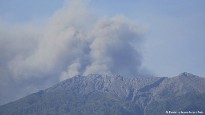 Miệng núi lửa Raunng ở Indonesia đột ngột nhả khói mù mịt lên bầu trời - Ảnh: AFP