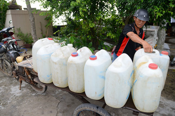 Người dân dùng can nhựa 20 lít chở nước về trữ khi TP Rạch Giá, tỉnh Kiên Giang bị nước mặn tấn công