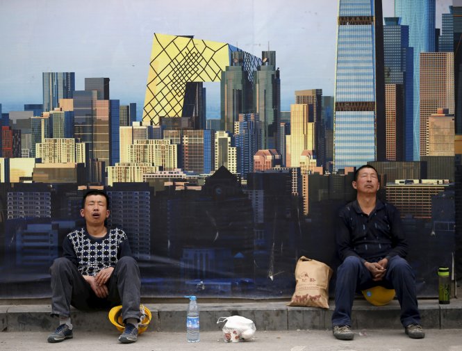 Công nhân tranh thủ ngủ sau giờ ăn trưa ở một công trình mới tại Bắc Kinh vào tháng 5-2015 Ảnh: Reuters