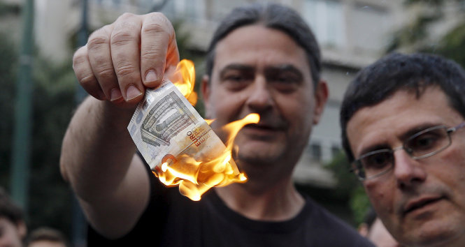 Những người dân Hi Lạp đốt tờ bạc euro nhằm phản đối chính sách khắc khổ của chính phủ - Ảnh: Reuters