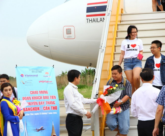 Những hành khách đầu tiên đặt chân xuống cảng hàng không quốc tế Cần Thơ được lãnh đạo sân bay tặng hoa chúc mừng. Ảnh: Chí Quốc