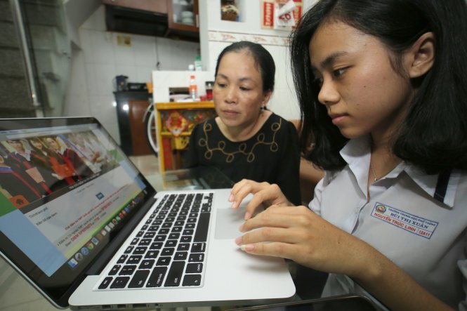 Thí sinh Nguyễn Trúc Linh (Trường Bùi Thị Xuân, TP.HCM) cùng mẹ theo dõi các trang mạng quảng cáo tra cứu điểm thi - Ảnh: Như Hùng