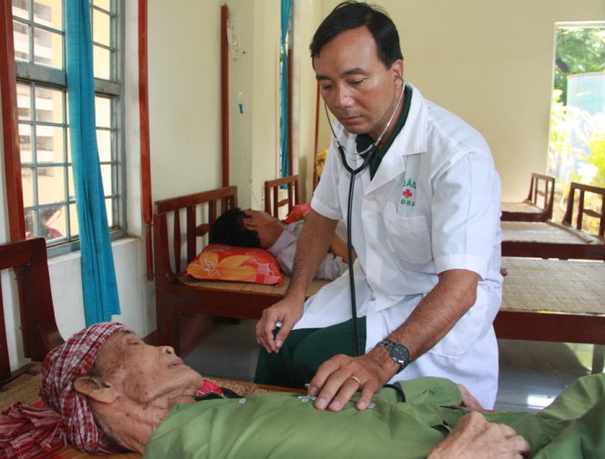 Thiếu tá Phan Minh Thu chữa trị cho các bệnh nhân người Campuchia tại đồn biên phòng Long Bình (An Giang)   Ảnh: SƠN LÂM