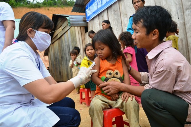 Cán bộ y tế tiêm chủng cho trẻ em thôn 8B, xã Phước Lộc - Ảnh: Lê Trung