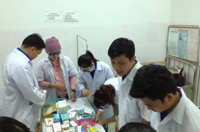 Các bác sĩ, sinh viên khoa dược, ĐH quốc tế Hồng Bàng đang sắp xếp thuốc để phát cho người bệnh tại huyện Châu Thành, An Giang - Ảnh: Quốc Anh