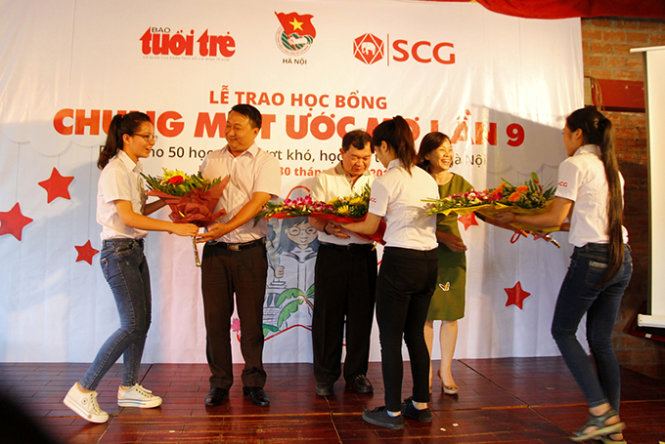 Đại diện các em học sinh lên cảm ơn và tặng hoa nhà tài trợ và Báo Tuổi trẻ - Ảnh: Nam Trần