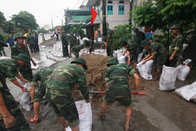 Lực lượng công binh tham gia đắp bờ chắn gia cố trạm điện Mông Dương - Ảnh: Tiến Thắng