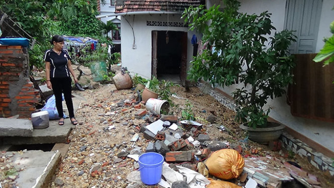Cô giáo Nguyễn Thị Thủy bên cạnh ngôi nhà tan hoang sau mưa lũ - Ảnh: Đức Hiếu