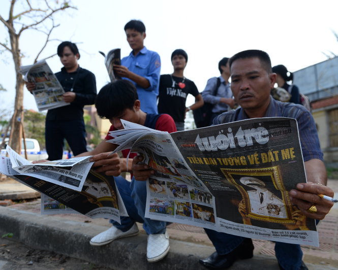 Người dân đọc báo Tuổi Trẻ đưa tin về tang lễ đại tướng Võ Nguyên Giáp trong ngày 12-10-2013