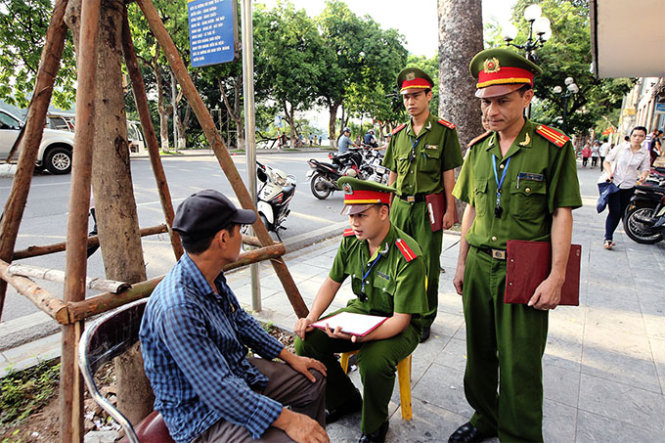 Sau khi dựng xe vào vị trí quy định, một nhóm cảnh sát khu vực đang tiến hành lập biên bản về lỗi buôn bán lấn chiếm vỉa hè của một người dân