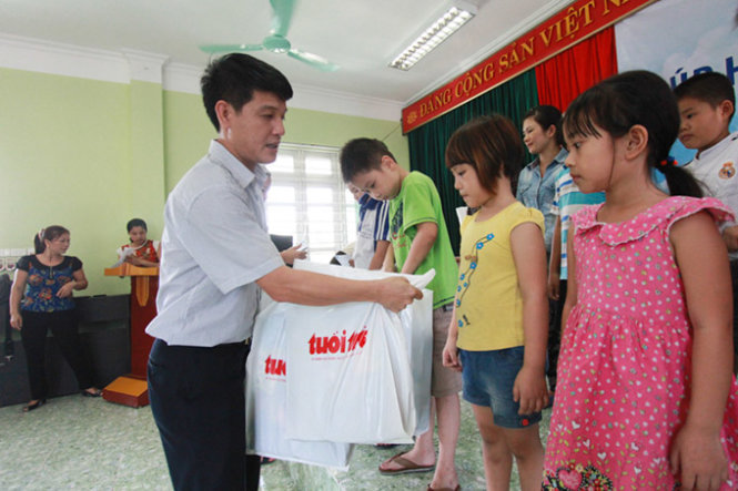Đại diện báo Tuổi Trẻ trao quà tặng của bạn đọc báo Tuổi Trẻ cho học sinh chịu thiệt hại trong trận mưa lũ vừa qua tại Quảng Ninh - Ảnh: Tiến Thắng