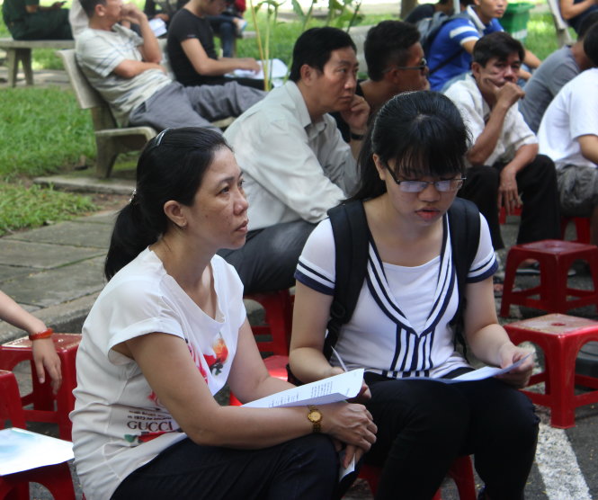 Phụ huynh và thí sinh ngồi chờ nộp hồ sơ xét tuyển tại Trường ĐH Bách khoa (ĐHQG TP.HCM) sáng 13-8. Ảnh - Phương Nguyễn.