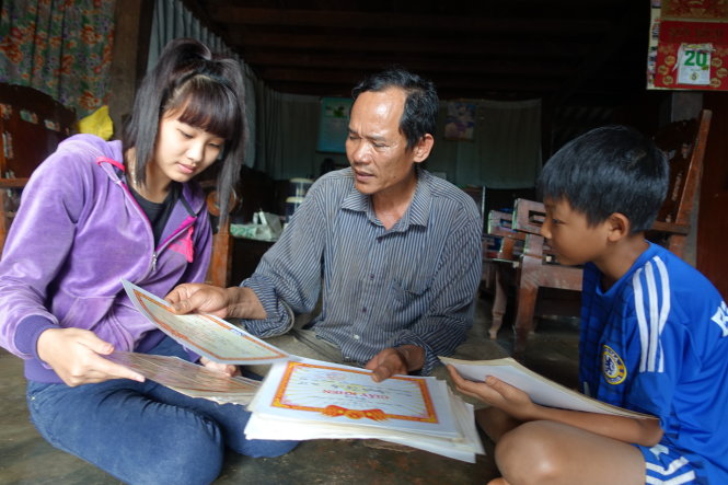 Ông Nguyễn Văn Chức hay lục lại giấy khen cũ của các con đã vào đại học để kể cho những người con nhỏ hơn về sự cố gắng của anh chị - Ảnh: Mai Vinh
