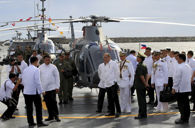 Tổng thống Benigno Aquino (giữa) cùng chuẩn đô đốc Caesar Taccad đi xem trực thăng hiện đại mới tiếp nhận tại trụ sở hải quân ở Manila ngày 10-8 Ảnh: Reuters