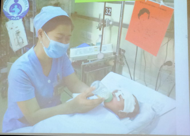 Bé Phát đang được một điều dưỡng cho bú bình tại khoa hồi sức sơ sinh. Ảnh: L.TH.H (chụp qua màn hình)