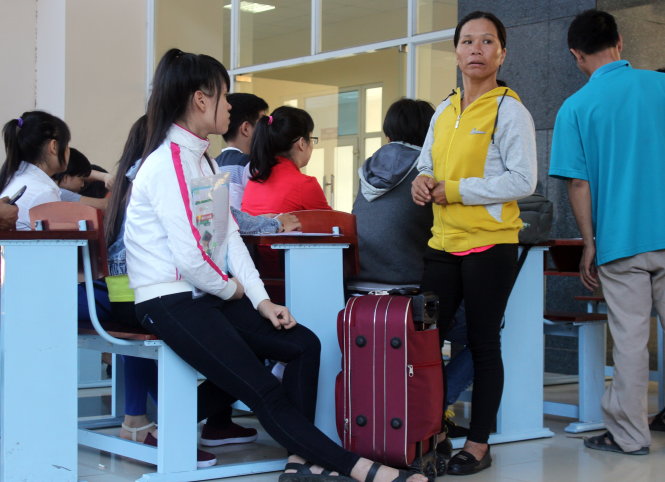 Bà Nguyễn Thị Tâm (Krông Pắk, Đắk Lắk) cùng con chờ rút hồ sơ tại Trường ĐH Y dược TP.HCM. Ảnh - Hải Quân