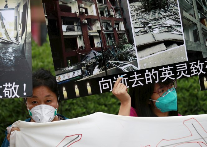 Người dân đeo khẩu trang biểu tình ở Thiên Tân ngày 18-8 đòi bồi thường - Ảnh: Reuters