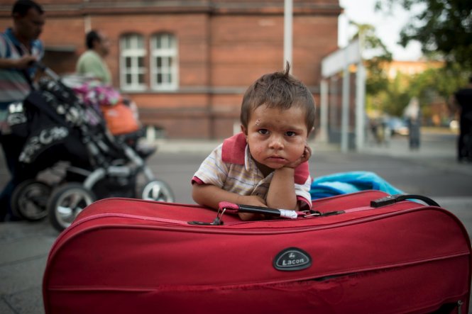 Một cậu bé đợi cha mẹ nộp đơn xin tị nạn ở Berlin, Đức             Ảnh: Reuters