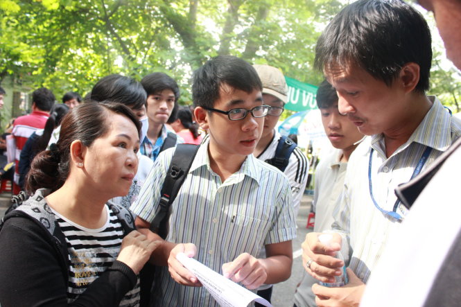 Phụ huynh và thí sinh vây quanh cán bộ tuyển sinh của Trường ĐH Bách khoa để nhờ tư vấn sáng 20-8. Ảnh - Hồng Nguyên