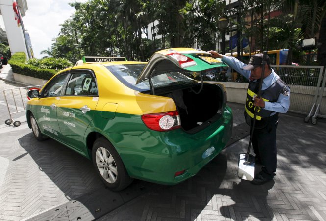Nhân viên bảo vệ kiểm tra cốp một chiếc taxi trước một khách sạn ở trung tâm Bangkok. Ảnh: Reuters