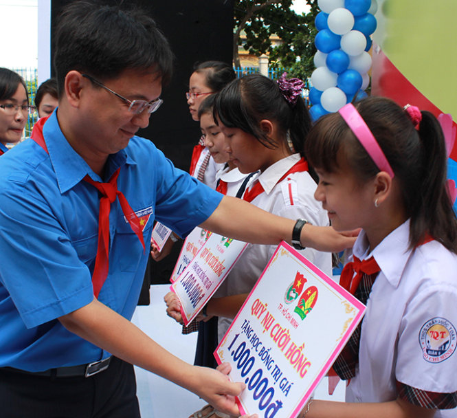 Bí thư Thành đoàn TP.HCM Nguyễn Mạnh Cường (trái) trao học bổng Nụ cười hồng cho học sinh có hoàn cảnh khó khăn - Ảnh: Q.L