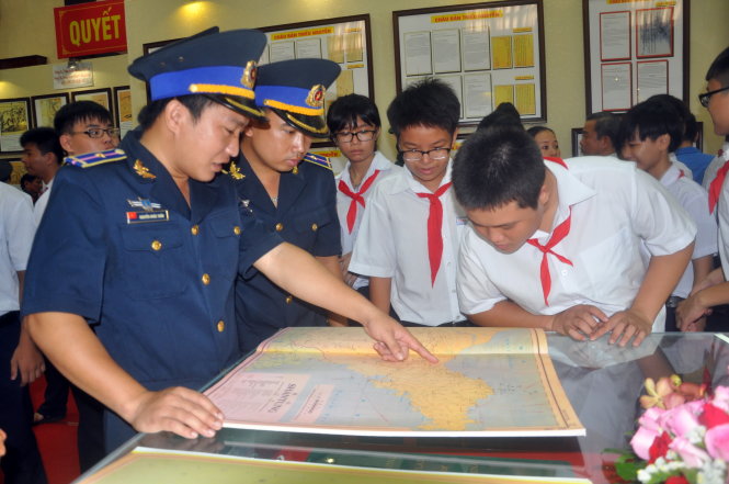 Sĩ quan cảnh sát biển chỉ dẫn cho học sinh Vũng Tàu xem bản đồ minh chứng chủ quyền của Việt Nam đối với hai quần đảo Hoàng Sa, Trường Sa - Ảnh: Đ.Hà
