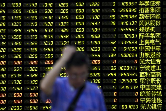 Một nhà đầu tư chứng khoán trước bảng điện tử hiển thị chỉ số chứng khoán Trung Quốc ngày 24-8 tại sàn giao dịch chứng khoán Hong Kong - Ảnh: Reuters