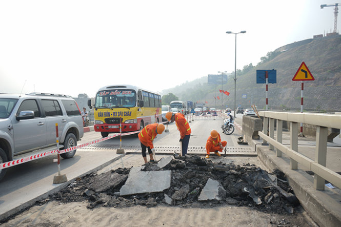 Các công nhân đang thu dọn lớp nhựa đường cũ được bóc lên - Ảnh: Đỗ Quang